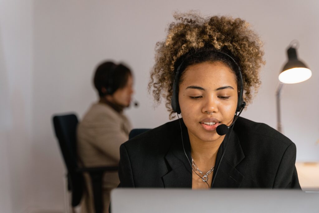 woman talking on headset while on computer